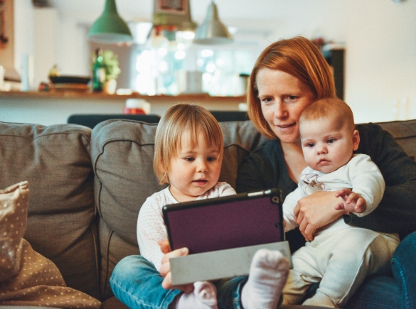 A mother plays with her two children at their house.