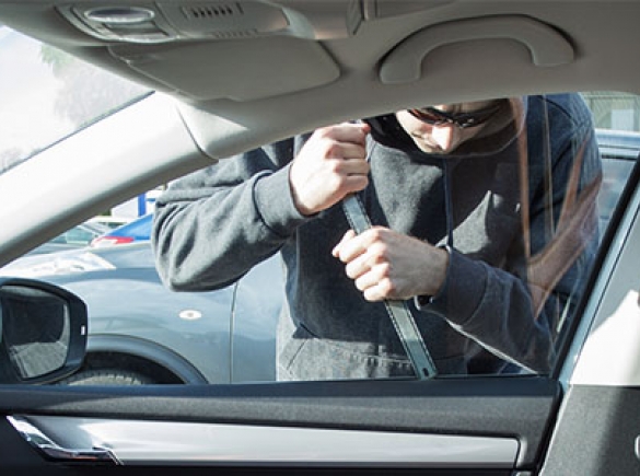 man trying to pick lock on car window