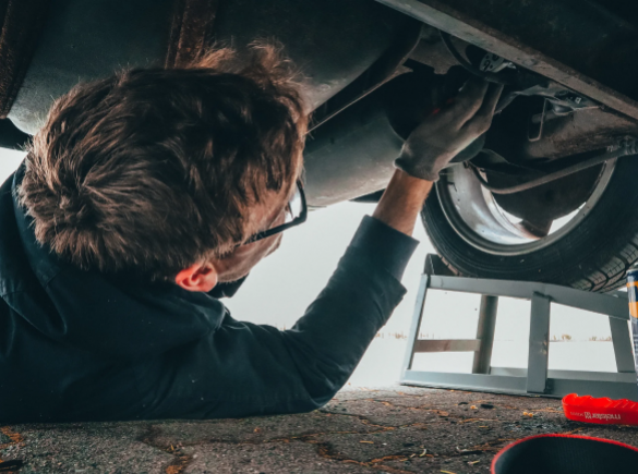 man working on repairing underside of vehicle