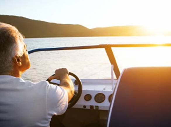 Man driving a boat with sunset