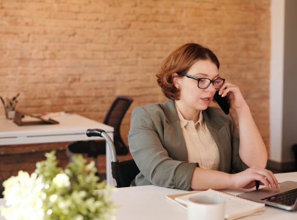 woman in office talking on phone and working