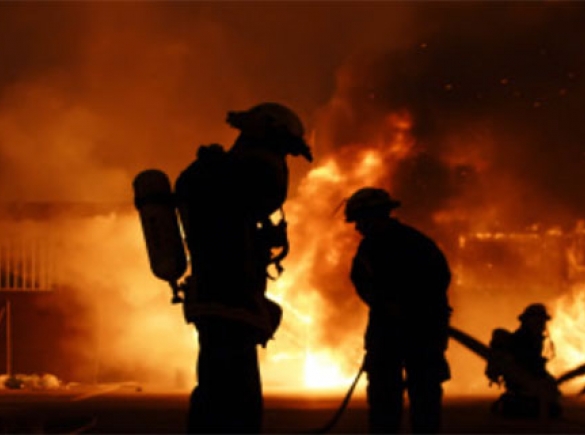 fire fighters silhouettes can be seen in front of a fire