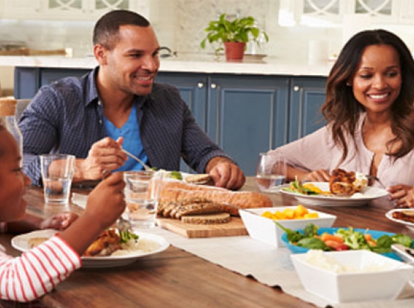 Happy family sitting together around dinner table