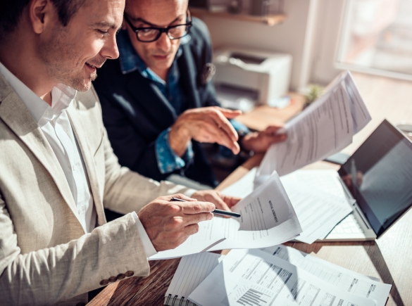 Two men reviewing insurance paperwork.