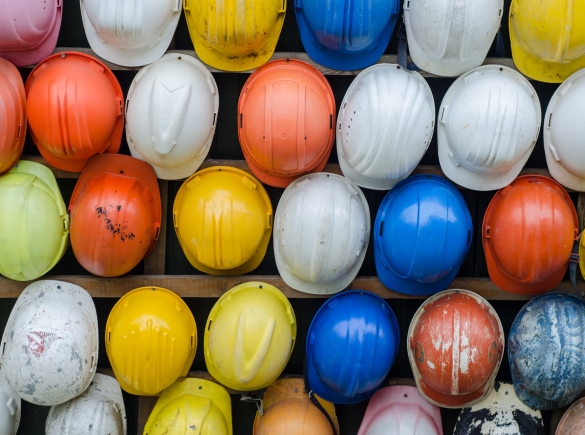 rows of workers helmets lined up on a rack