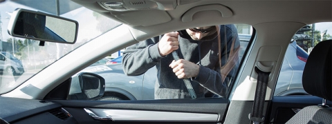 man trying to pick lock on car window