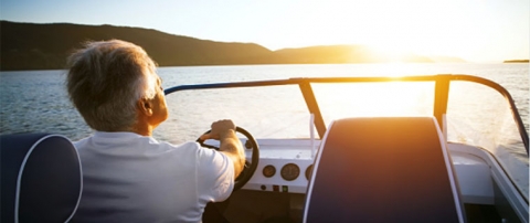 Man driving a boat with sunset