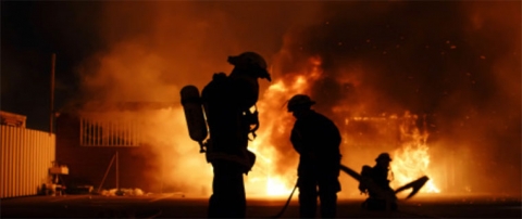 fire fighters silhouettes can be seen in front of a fire