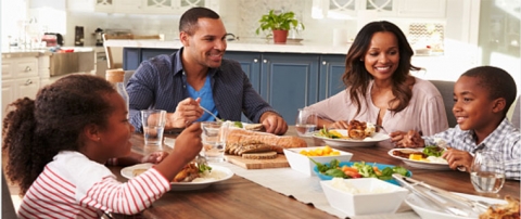 Happy family sitting together around dinner table