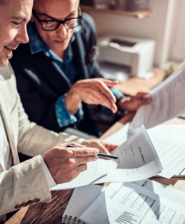 Two men reviewing insurance paperwork.